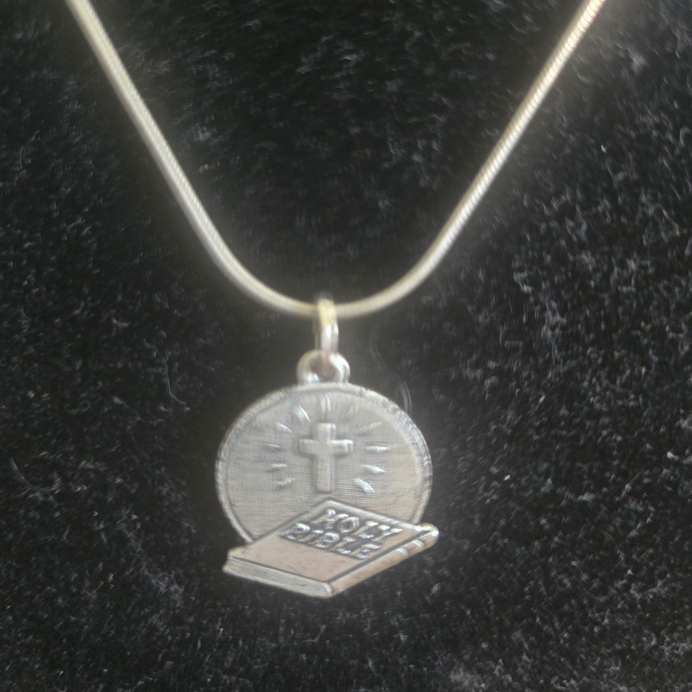 Sterling Silver charm With Chain
Cross w/radiant detailing + Holy Bible design